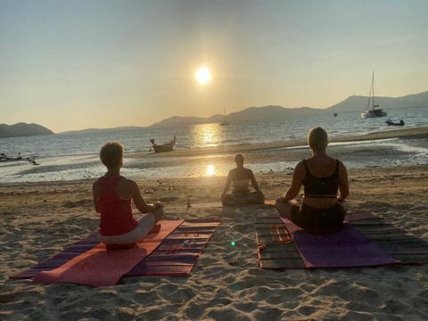 Meditatie bij zonsondergang op het strand in Phuket
